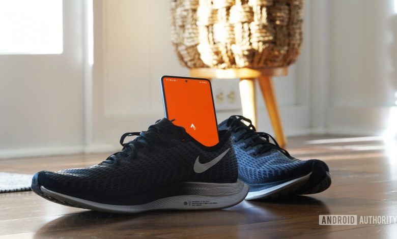 A Galaxy A51 rests in a running sneaker, displaying the Strava app logo.