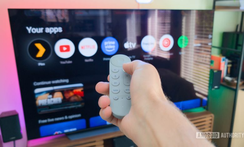 Google TV Streamer remote in hand controlling TV