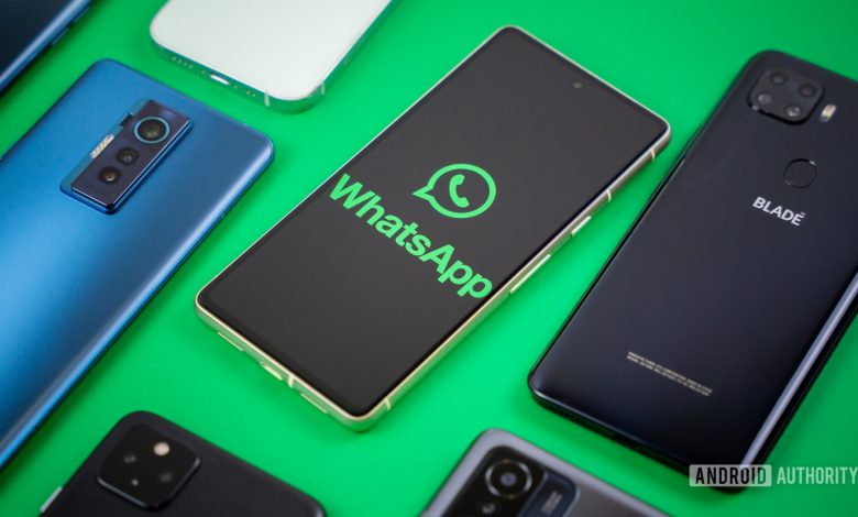 WhatsApp logo on smartphone next to other devices Stock photo 3