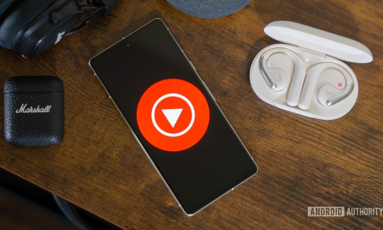 YouTube Music logo on smartphone, next to headphones and Nest Mini (2)