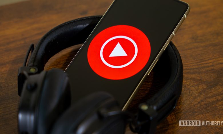 YouTube Music logo on smartphone with headphones