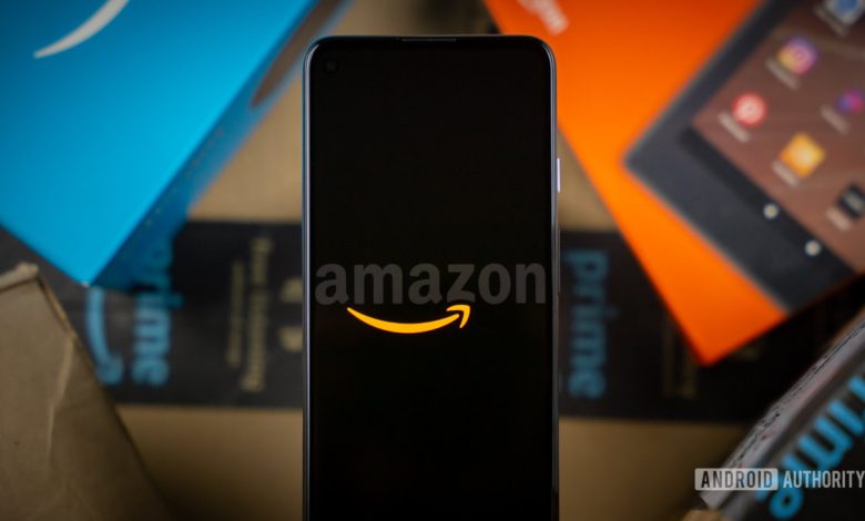 Amazon logo on phone next to boxes stock photo 11