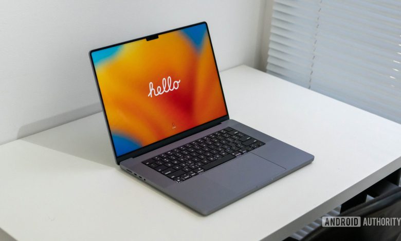 Apple MacBook Pro 2023 showing hello welcome screen sitting on a table