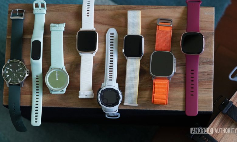 Wearables from various brands rest on a wooden box.