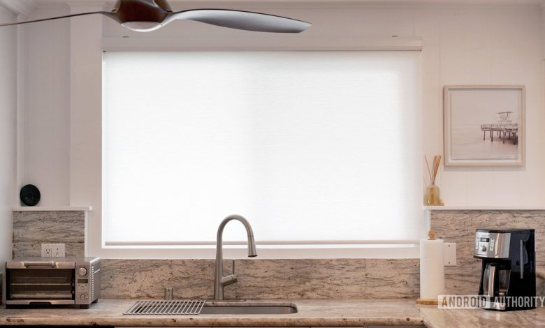 A partial sheer smart blind lets sunlight into a kitchen while still allowing privacy.