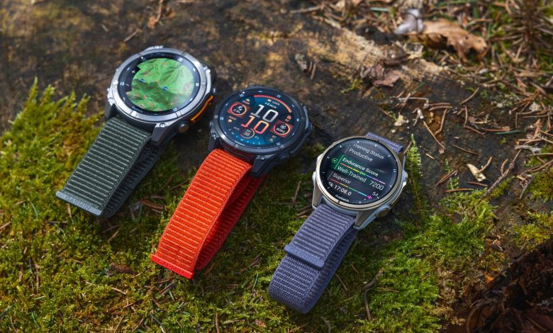 Three Garmin fenix 8 devices rest on a mossy surface.