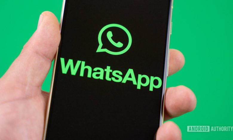 Holding smartphone with WhatsApp logo on the screen Stock photo