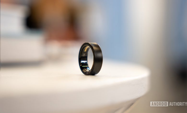 A Black Titanium Samsung Galaxy Ring rests on a white surface.