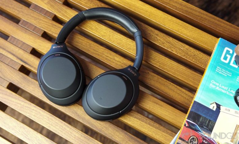 Sony WH-1000XM4 headphones next to magazines on a wood bench