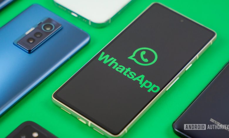 WhatsApp logo on smartphone next to other devices Stock photo 1