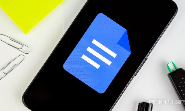 Google Docs logo on smartphone next to office gear stock photo 4