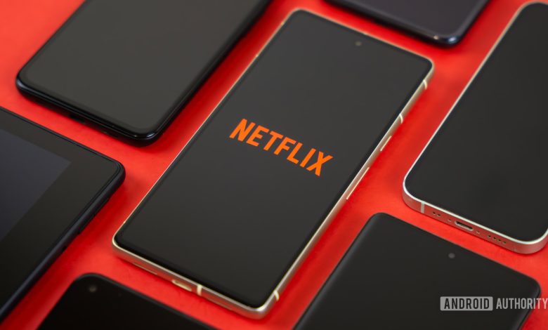 Netflix logo on smartphone, next to other devices stock photo (3)