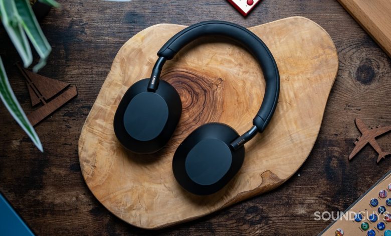 Sony WH 1000XM5 headphones laying flat on wooden table.