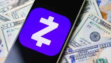 Zelle logo on smartphone with cash on background stock photo (2)