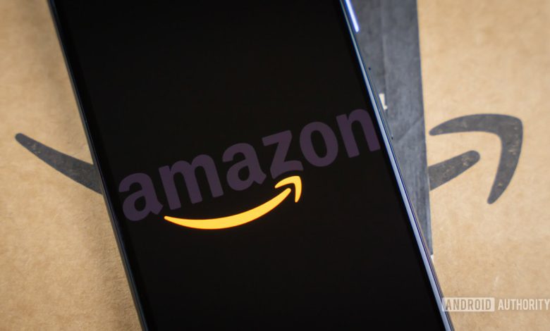 Amazon logo on phone next to boxes stock photo 15